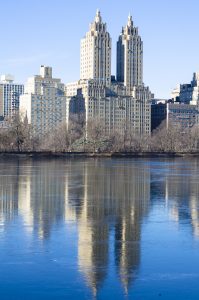 two old skyscrapers with reflection in water