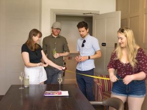 four people, table, and a tape measure